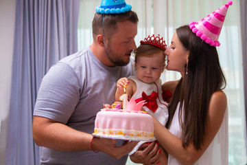 family celebrates their daughter's first birthday, one year old, a cake, a close-up. happy family concept.