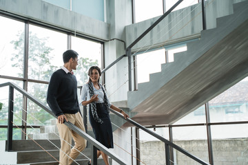 business people walking on stairs in the office and chatting