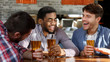 © Prostock-studio - Friends meeting. Men drinking beer and talking in bar