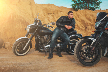 Smiling happy biker in sitting unknown on big chopper bike on road