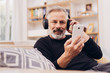 © contrastwerkstatt - Senior bearded man relaxing listening to music
