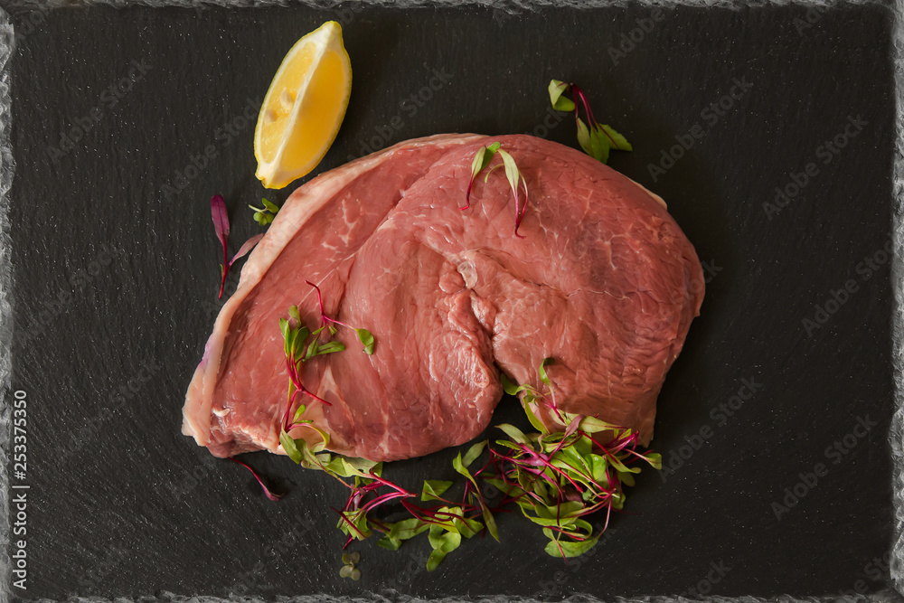 red meat rump beef steak fresh raw on a black background slate plate ...