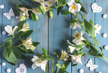 Mock up blank paper on blue wooden background with flowers of white color. Blank, frame for text. Greeting card design. View from above