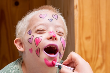 Preparing and painting the face of a boy with the down syndrome to the house show.