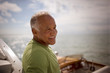 © Erickson Stock - Mature adult man sitting on a boat.