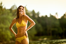 Beautiful Young Woman Wearing A Yellow Bikini In A Lake.
