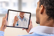 © JPC-PROD - virtual live chat with the patient with digital tablet and a doctor via internet. In-home care for a young male patient in telemedicine or telehealth,