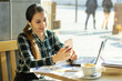 © Vasiliy - beautiful girl in cafe, sms on the phone, listening to music on headphones
