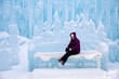 woman sitting on an ice bench at the ice castles