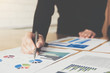 © wichayada - Businesswoman pen pointing graph chart in this mounth for Plans to improve quality next month.