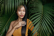 Hair beauty. Woman model with long straight hair in palm leaves