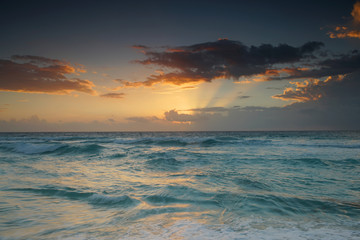 Wall Mural - sunrise with light from behind the cloud and reflection in the ocean