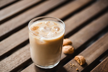 Wall Mural - Ice latte in glass and amaretti cookies on wooden table. Morning drink