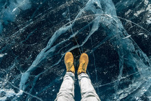 Men's Yellow Shoes On The Pure Blue Ice Of Lake Baikal. Concept Tourism And Travel To Famous Places Of Nature