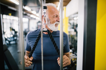 Happy senior people doing exercises in gym to stay fit