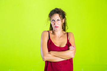 portrait of an upset young casual girl standing with arms folded