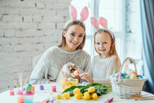 Easter Preparation.The Little Daughter With Her Mother Stroke A Home Decorative Rabbit.