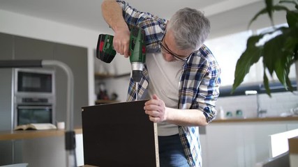 Wall Mural - Man drilling holes in plank in modern kitchen