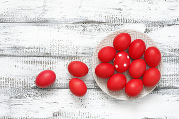 Wall Mural - Red Easter eggs in plate on wood