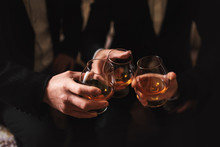 Business Meeting. Men Hold Glasses Of Whiskey. Men's Party. Hand With A Drink Of Alcohol