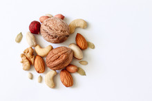 Assorted Nuts On A White Table. Hazelnuts, Cashews, Peanuts, Walnuts, Almonds.