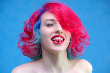 High fashion model woman with multi-colored hair posing in the studio, portrait of a beautiful sexy girl with a fashionable makeup and manicure.