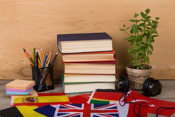Fototapete - flags, books, headphones, pencils on wooden background