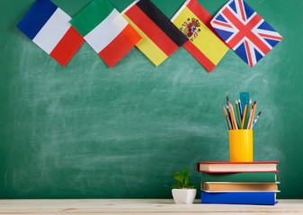 backpack, flags of Spain, France, Great Britain and other countries, books and school supplies of the blackboard