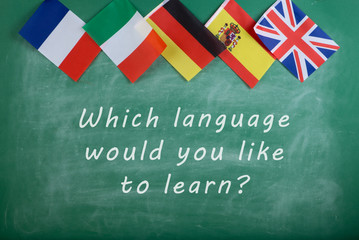 Fototapete - flags of Spain, France, Great Britain, Russia and Italy and blackboard with text 