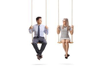 young man and woman sitting on a swing and looking at eachother