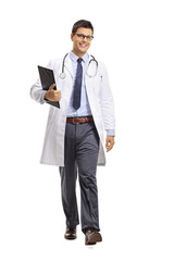 Wall Mural - Young male doctor holding a clipboard and walking towards the camera