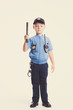 Cute little police boy with smile on face and baton on white background. Intelligent cool children in police suit with blue eyes and baton regulates traffic