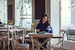 © Olena_Molchanova - the woman in the cafe sits at a table, drinks coffee and looks at window