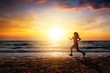 Silhouette einer sportlichen Frau die am Strand bei Sonnenuntergang trainiert