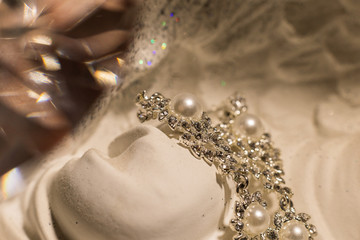 Beautiful jewelry on white stone illuminated by light.