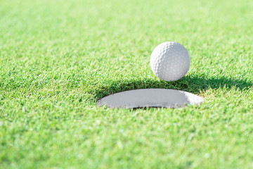 Canvas Print - Golf ball and golf hole on green grass with copy space