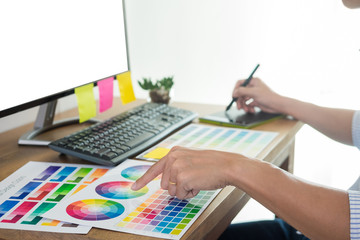 Poster - designer editor at work drawing sketches a new project on graphic tablet and color palette sitting a