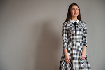 Portrait of flirtatious girl with green eyes in plaid college uniform