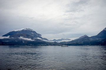 Italy, Varenna, Lake Como, boat in a serene scene with snow cap mountain