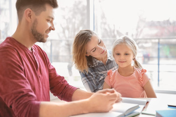 Sticker - Little girl with parents doing homework at home