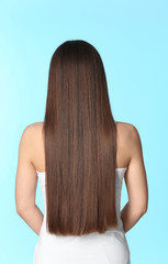 Wall Mural - Woman with long brown hair on color background