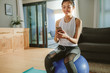 © Jacob Lund - woman with smartphone relaxing on a fitness ball