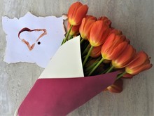 Orange Tulips And Heart Blood On A Gray White Background. The Concept For The Postcard, Holiday