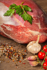 Wall Mural - Raw beef on a wooden background with spices and vegetables.