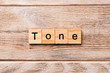tone word written on wood block. tone text on wooden table for your desing, concept