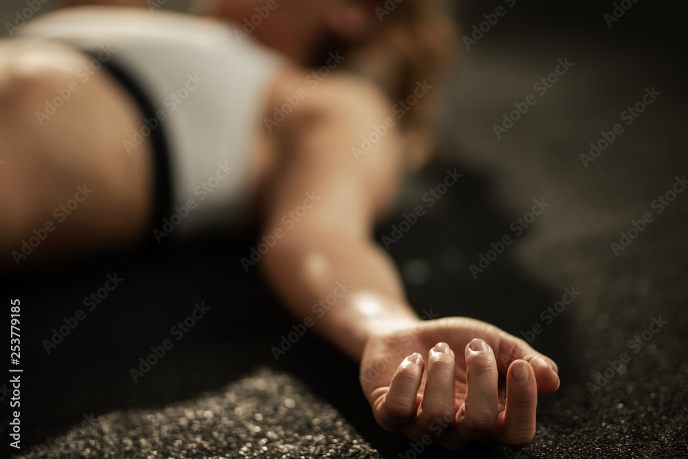Close up of exhausted athlete resting on the floor after sports training. - obrazy, fototapety, plakaty 