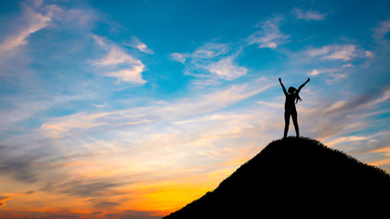 Silhouette woman on top hill in sunet