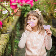 Little girl playing with flowers in greenhouse.
