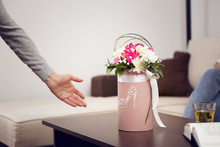 A Woman's Hand Shows A Flower Box That Is On The Table.