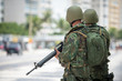 Two Brazilian Army soldiers standing in full camouflage uniform on the boardwalk at Copacabana Beach in Rio de Janeiro, where crime is a persistent problem